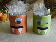 two tin cans decorated like monsters with forks in them