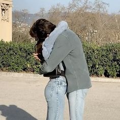 a woman in jeans and jacket leaning on a skateboard with her head against her hands