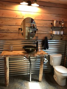 a bathroom with a toilet, sink and mirror in it's centerpieces