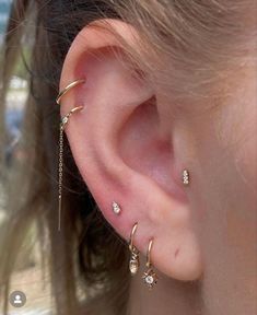 a close up of a person's ear with three different types of piercings