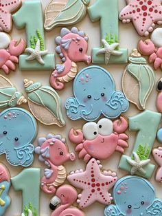 decorated cookies are arranged in the shape of numbers and sea animals for first birthdays