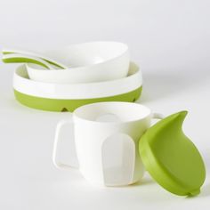 three white and green cups with spoons