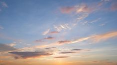 the sun is setting over an ocean with boats on it's shore and clouds in the sky