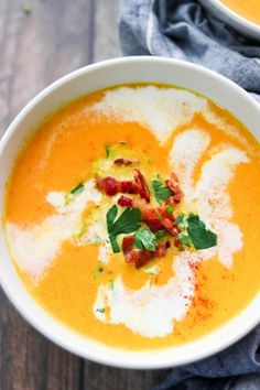 two bowls filled with soup on top of a wooden table