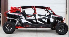 a white and red polaris vehicle parked in front of a garage