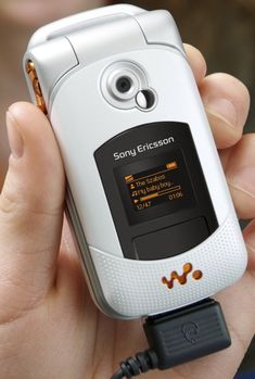 a person holding a cell phone in their hand with an mp3 player attached to it