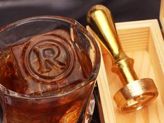 a close up of a drink in a glass on a tray with a wooden spoon