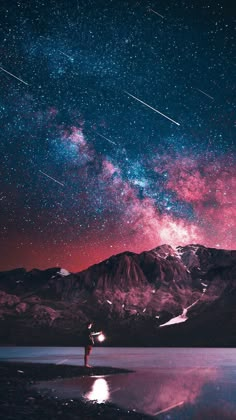 the night sky is filled with stars and bright lights, as well as some mountains