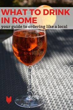 a glass of wine sitting on top of a table next to an orange and text that reads, what to drink in rome your guide to ordering like a local