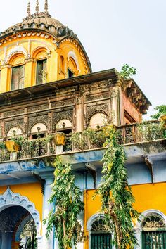 an old building with lots of plants growing on it's balcony and balconies