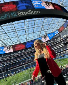 a woman standing in the middle of a football stadium