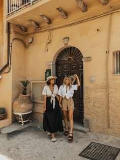 two women walking in front of a building