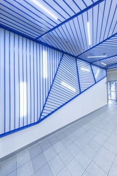 an empty room with blue lines on the ceiling and tile flooring in front of it