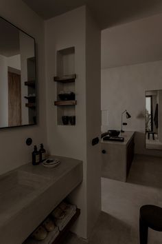 a bathroom with a sink, mirror and shelves on the wall next to each other