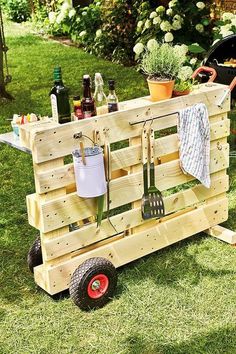 a wooden cart with utensils on it in the grass