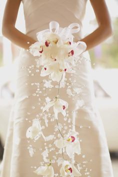 a woman in a white dress holding a bouquet of flowers