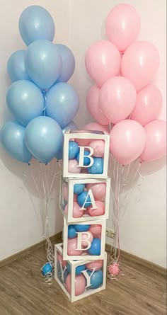 some balloons are in the shape of blocks with letters on them and blue, pink, and white balloons