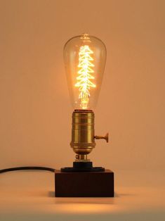 a light that is on top of a wooden block with a wire attached to it