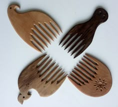 four wooden combs and two birds on a white surface with one bird cut in half