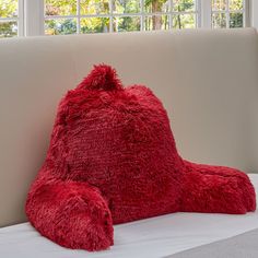 a large red teddy bear sitting on top of a couch