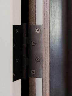 an image of a door handle on the side of a wooden door with white and black trim