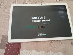 the samsung galaxy taba 7 tablet is laying on top of a tablecloth covered surface