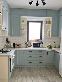 a kitchen with light blue cabinets and white counter tops is seen in this image from the front