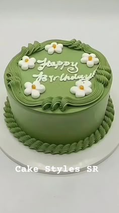 a green birthday cake with white flowers on it