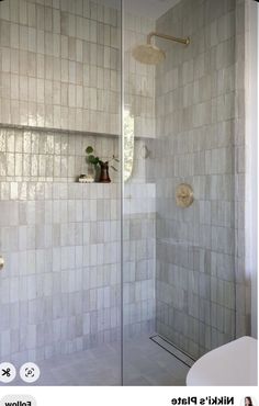 a white tiled bathroom with a walk in shower