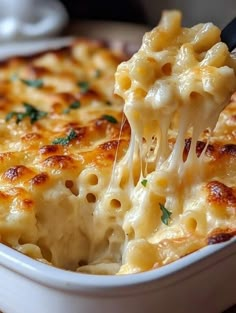 a spoonful of macaroni and cheese being lifted from a casserole dish