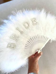 a person holding a white fan with the word dad written on it and diamond embellishments