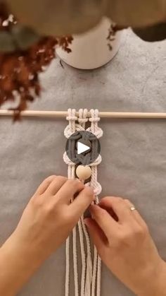 someone is working on something that looks like an ornament with ropes and beads