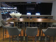 an empty room with chairs and tables in front of a large screen on the wall