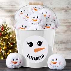 a bucket filled with white stuffed animals sitting next to a christmas tree