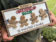 a man holding up a sign with gingerbreads on it