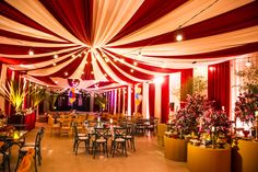 the interior of a restaurant with tables and chairs covered in red and white drapes