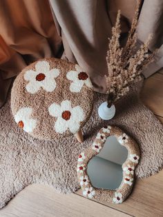 a small round mirror sitting on top of a rug next to a vase with flowers