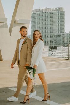 a man and woman are walking together in front of tall buildings