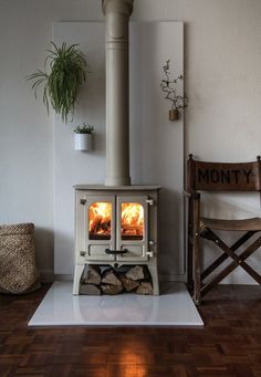 a stove that is sitting in the middle of a room next to a wooden chair