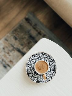 a cup of coffee sitting on top of a white table