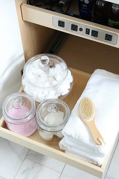 an open drawer with various items in it and a wooden spoon on the bottom shelf