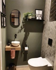 a bathroom with a toilet, sink and mirror on the wall next to each other