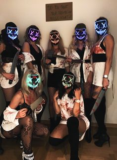 a group of women dressed up in costumes with neon lights on their faces and hands