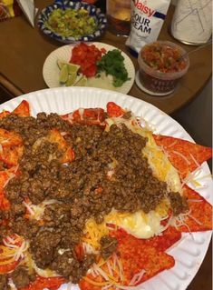 a paper plate topped with lots of different types of food on top of a table