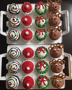 two trays filled with cupcakes covered in frosting and decorated to look like reindeer heads