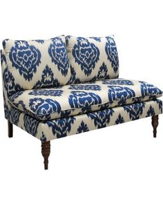 a blue and white patterned couch with wooden legs