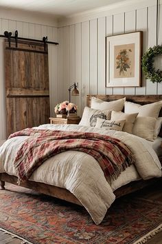 a bedroom with a bed, rug and wooden headboard on the floor in front of a barn door