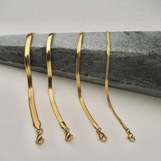 Our Snake Chain Bracelet is your perfect go-to accessory for everyday bracelet stacking support. With its flat lay design, it'll instantly add a touch of edge to your look! Materials: Gold stainless steel (No Tarnish) Flat snake chain Lobster claw clasp Measurements: 2mm width, 6" long with 2" extender 3mm width, 6" long with 2" extender 4mm width, 6" long with 2" extender 5mm width, 7" long with 2" extender Gold Snake Chain Bracelet, Snake Chain Gold, Flat Snake Chain, Mandala Digital, Real Gold Chains, Gold Snake Chain, Diamond Pendants Designs, Modern Gold Jewelry, Art Jewelry Design