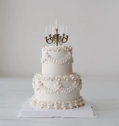 a three tiered wedding cake with candles on top