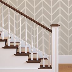 a stair case next to a wall with a chevron pattern on it